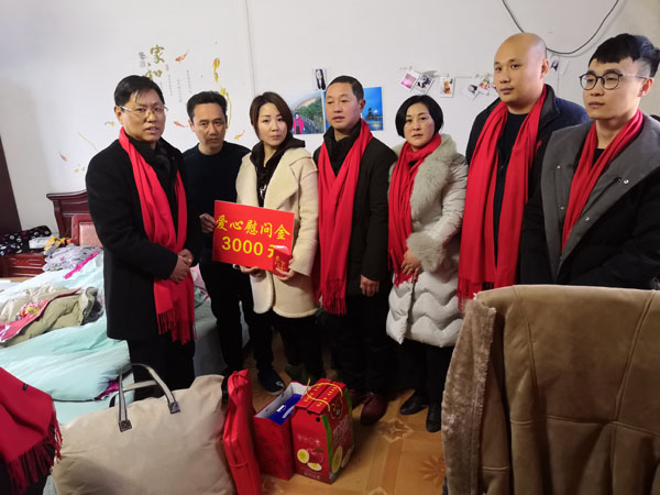 熊桂祥會長(左一)、徐敏秘書長(右三)、許生永經理(右二)、謝炳浩總助(右一)給楊白林特困戶家送上慰問金和慰問物品,圖為他們與長年臥病在床的楊白林夫婦的一雙整日侍奉兒女(左二、左三)及霍邱縣河口鎮領導(中)合影留念