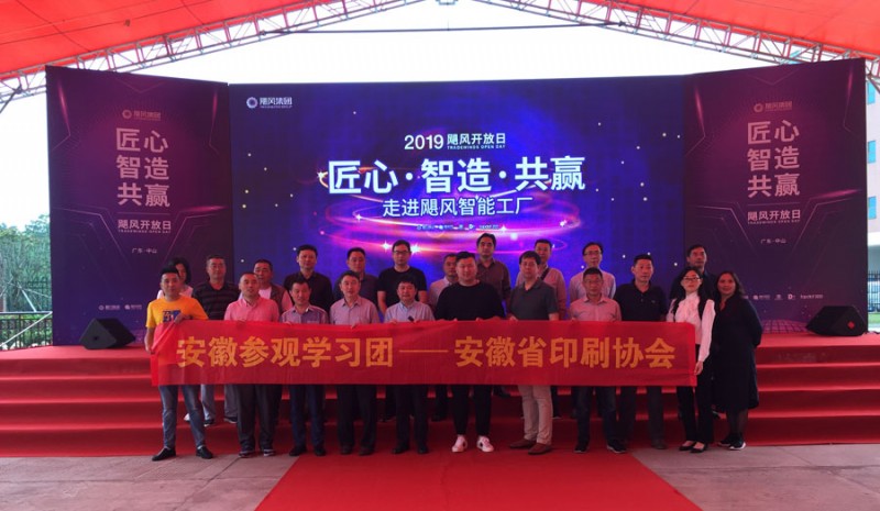 觀展團部分團友在颶風網集團旗下的富日智能工廠開放日活動展臺前合影