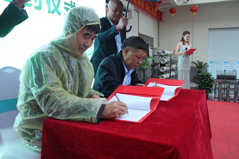 廣力總裁徐貴山與河北省唐山市潤(rùn)豐印務(wù)有限公司董事長(zhǎng)薄會(huì)川(穿雨衣者)在《購(gòu)機(jī)協(xié)議書(shū)》上簽名